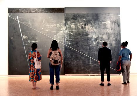 Dyson Opening. Four students looking at large abstract grey piece on wall.