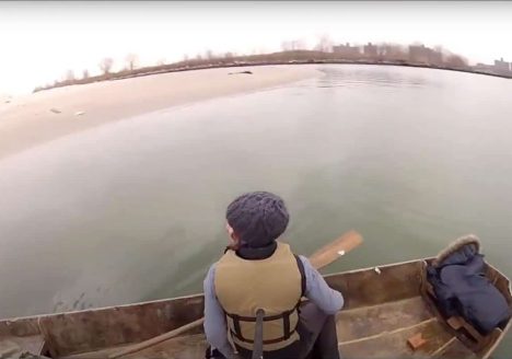 Fisheye camera photo of a woman on a boat on a lake.